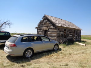 The new Volkswagen Golf SportWagen sits outside a near-100-year-old homestead shack in northwestern Logan County. (Jan Wells photo)